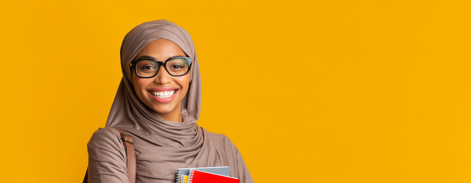 Smiling student holding notebooks